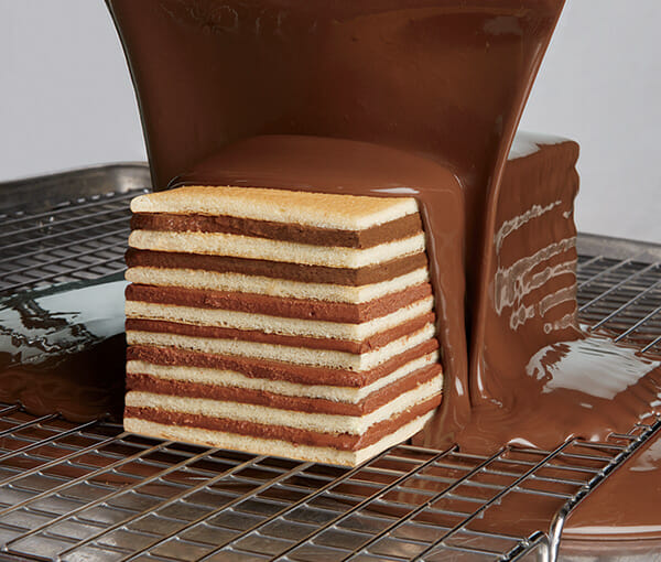 Layered Torte Cake with Chocolate being Poured Over it