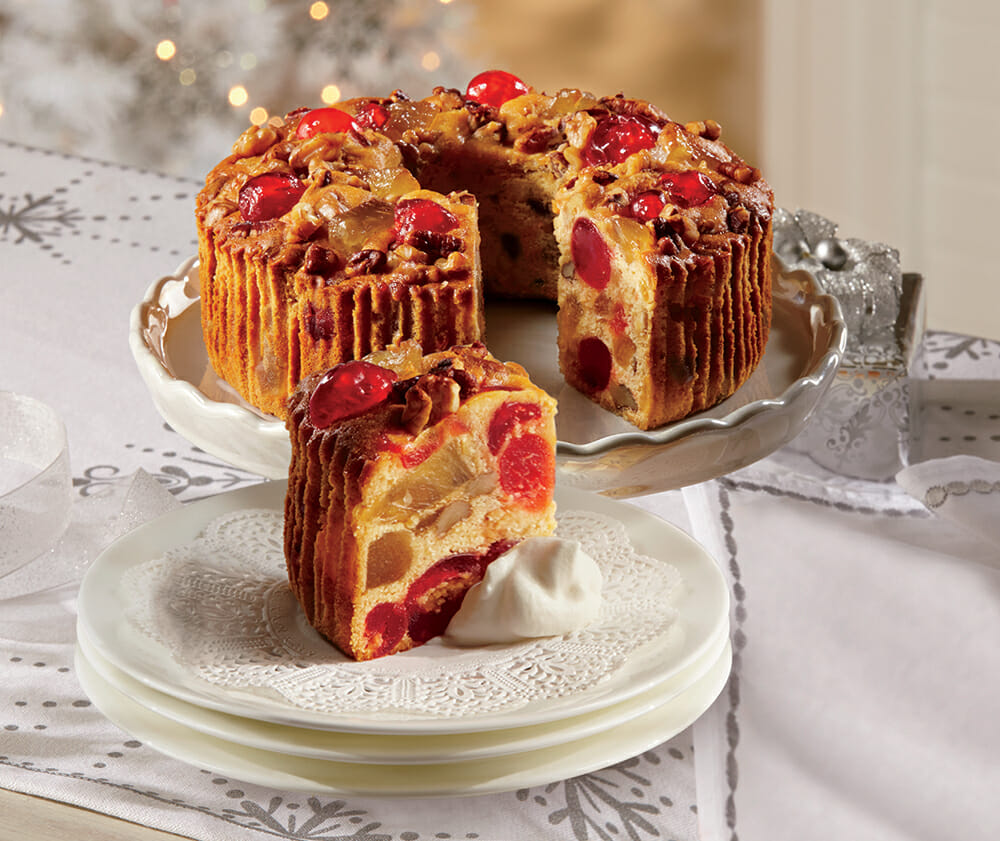 Butter Rum Fruitcake on a dessert stand and dessert plates
