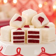 Red velvet petits fours in a stack with two cut in half